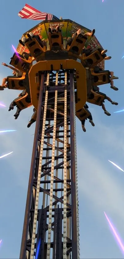 Thrilling upward view of a drop tower ride at an amusement park with a blue sky.