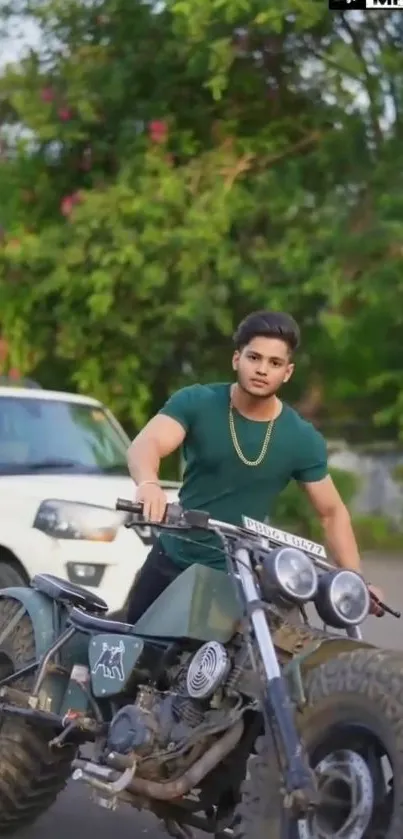 Man posing on a motorcycle against a green backdrop.