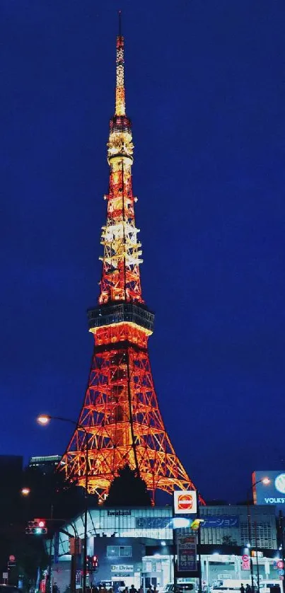 Tokyo Tower illuminated at night with vibrant blue sky.