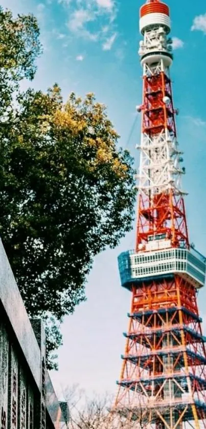 Tokyo Tower with vibrant sky and green trees in the foreground.