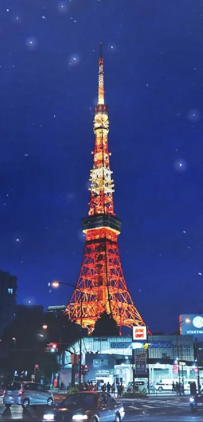 Tokyo Tower glowing at night with city lights and deep blue sky.