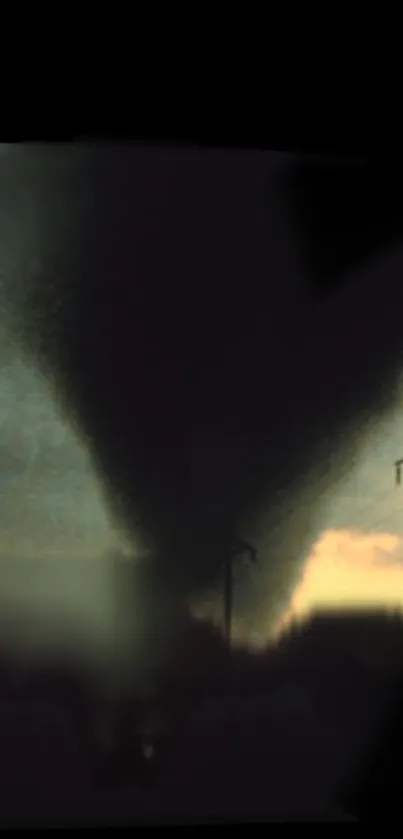 Tornado under a dramatic sky with power lines silhouetted at dusk.