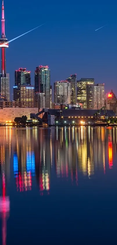 Toronto skyline at night with colorful city reflection in water.