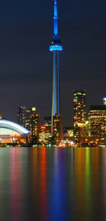 Toronto skyline at night with CN Tower reflections on Lake Ontario.