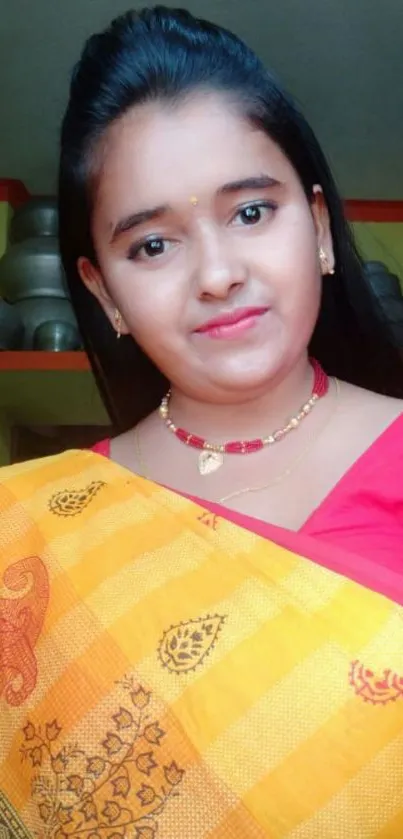 Woman in a vibrant yellow sari with a red blouse.