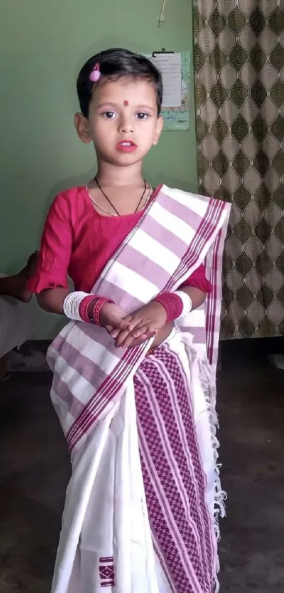 Young child in traditional attire, posing gracefully.