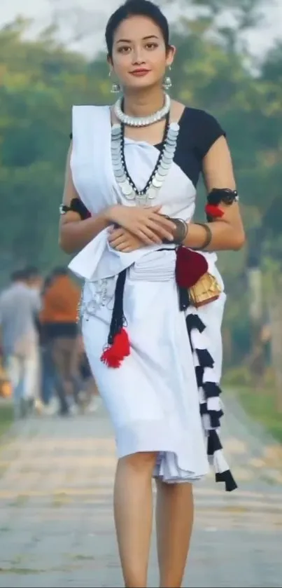 Woman in traditional attire walking on a scenic path.