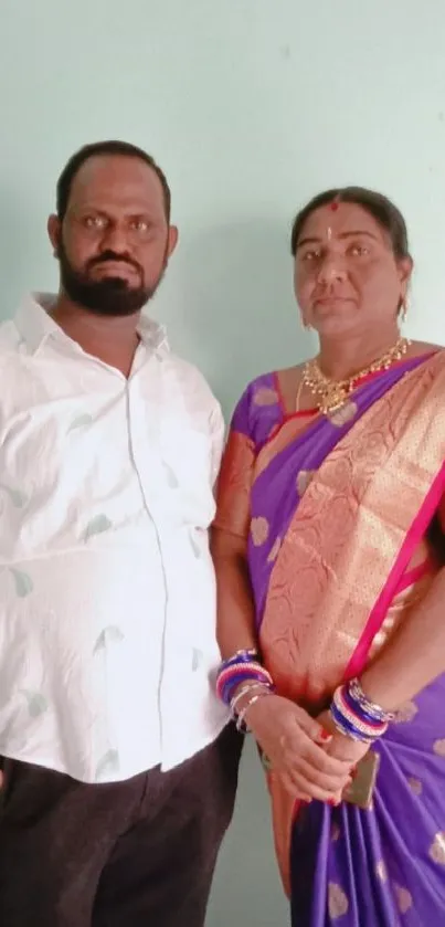 Couple in traditional Indian attire posing indoors.