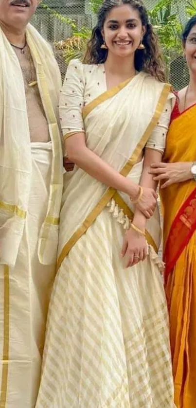 Family in elegant traditional attire smiling outdoors.