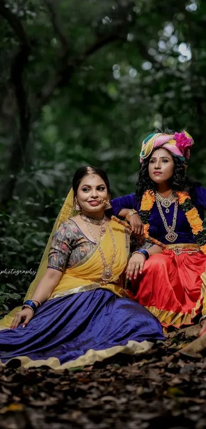 Two people in traditional dresses sitting in a forest