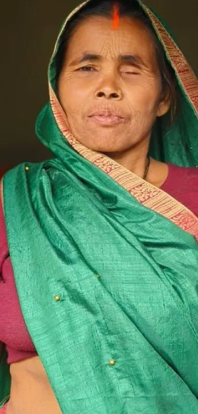 Woman in a vibrant green saree smiling gracefully.