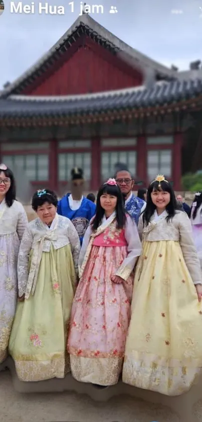 Group in traditional hanbok attire with historical backdrop.