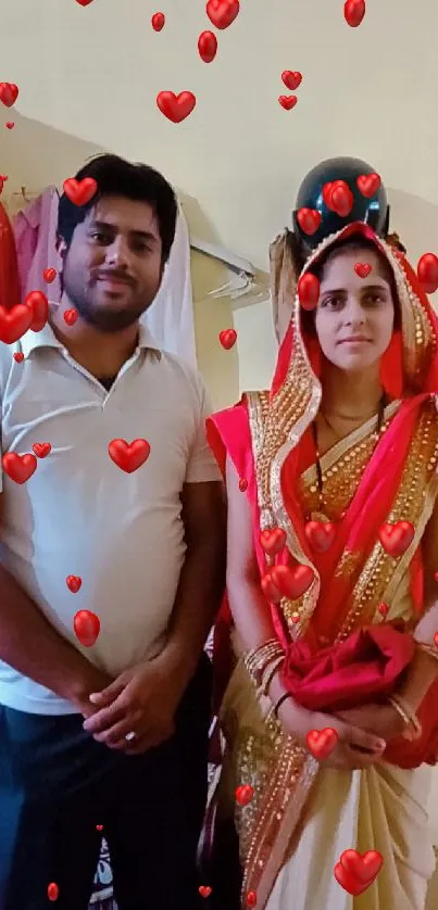 Couple in traditional Indian attire with red and beige saree in an indoor setting.