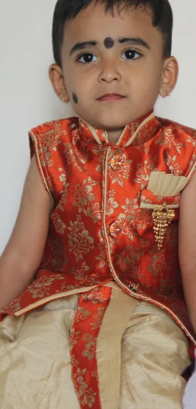 Child in traditional Indian attire with floral embroidery.