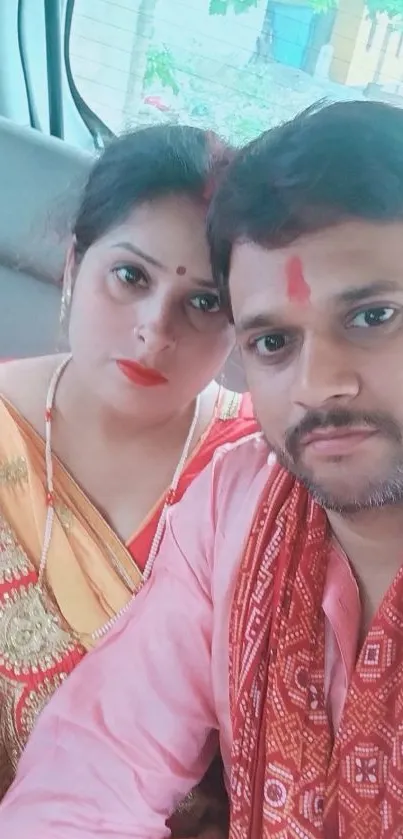 Indian couple in traditional attire in a car.