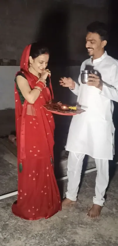 Couple performing a traditional Indian ritual in vibrant attire.