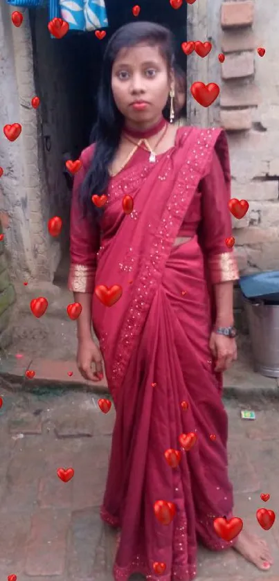 Woman in traditional red saree in rustic setting.