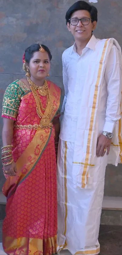 Couple in traditional Indian wedding attire with vibrant saree and dhoti.