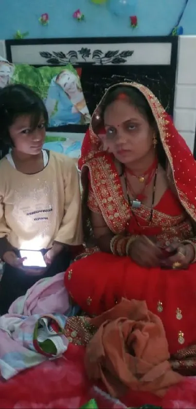 Indian bride with child in traditional attire on a colorful bed.