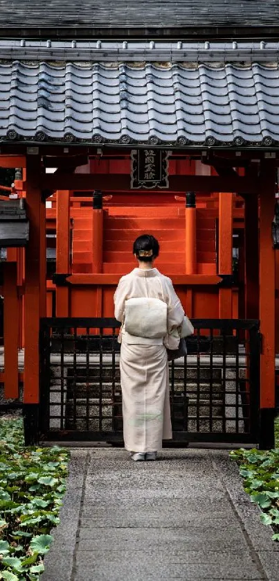 Woman in kimono at a vibrant red Japanese shrine.