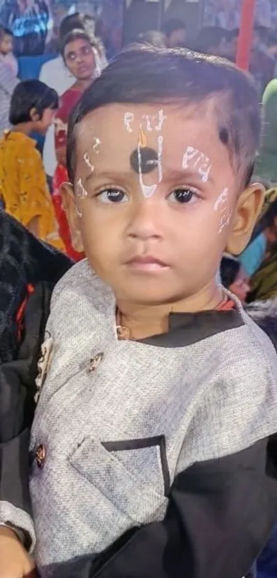 Portrait of a child in traditional attire at a festive event.