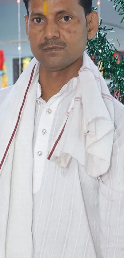 Man in white attire with festive background.