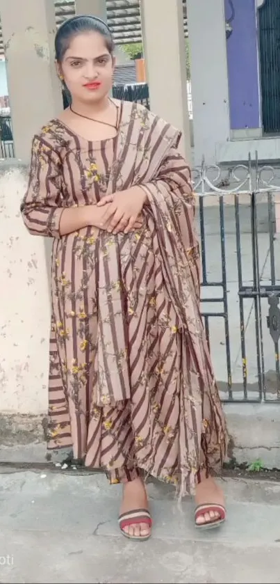 Woman in traditional attire standing outdoors.