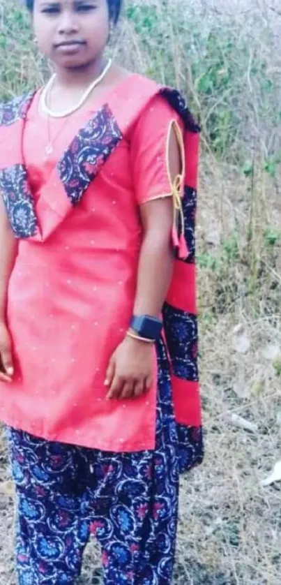 Woman in a vibrant red traditional outfit outdoors.