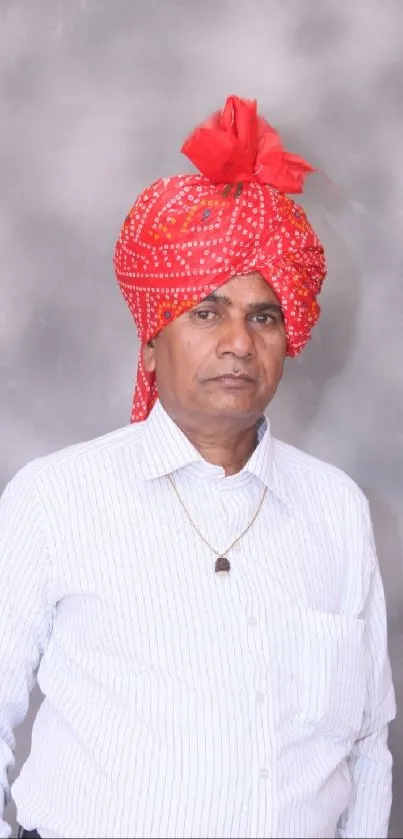 Man wearing a traditional red turban and white shirt.