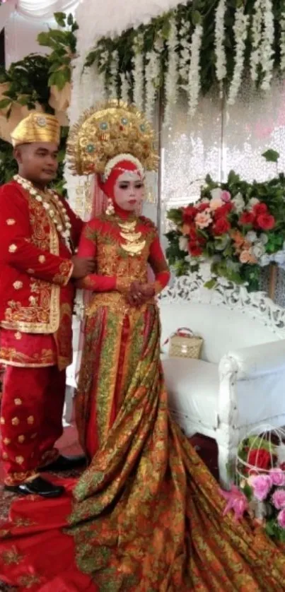 Couple in traditional wedding attire with floral background.