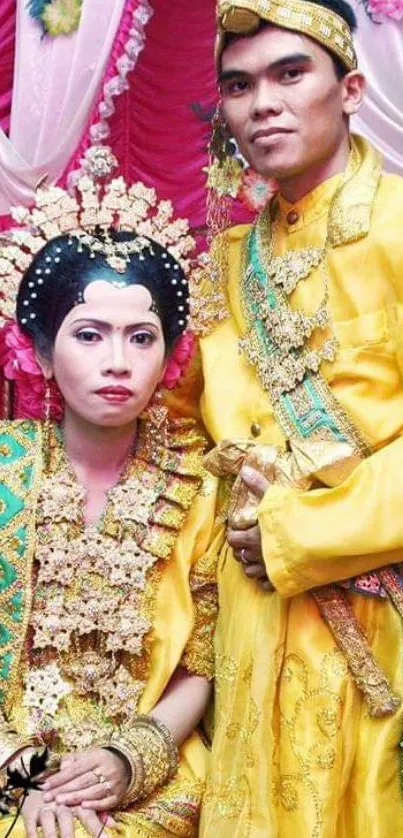 Couple in traditional yellow wedding attire with ornate accessories.