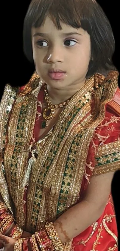 Child in traditional ornate attire with black background.