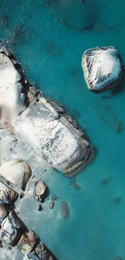 Aerial view of turquoise ocean with rocks.