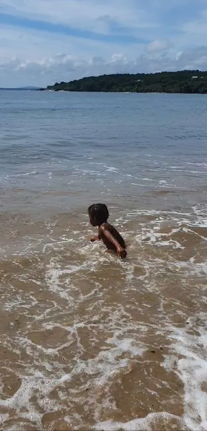 Child in ocean with blue sky and waves on a sunny beach day.