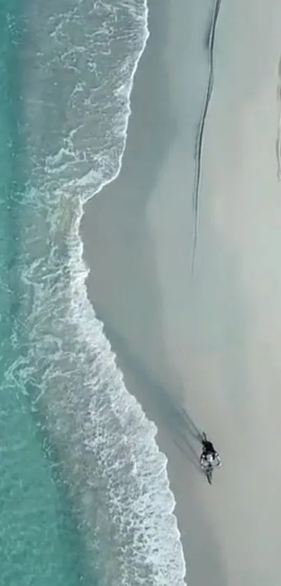 Aerial view of a tranquil beach with turquoise waters and soft sandy shores.