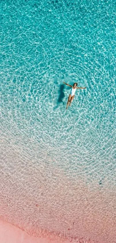 Aerial view of a serene beach with turquoise waters and pink sand.