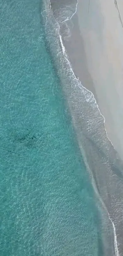 Aerial view of tranquil turquoise beach with gentle waves and sandy shores.