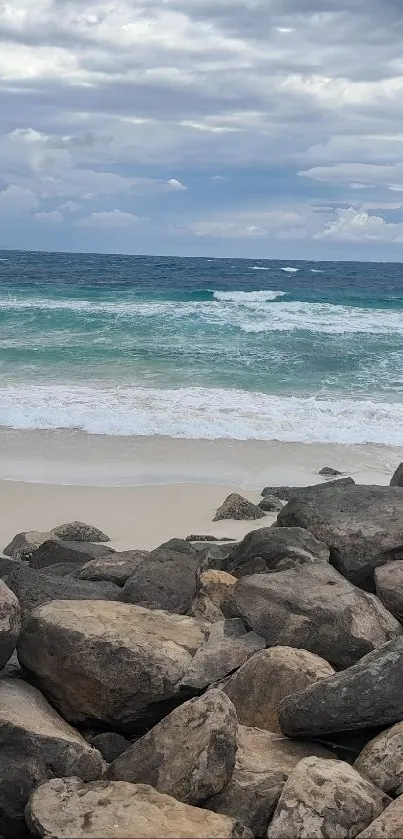 Beach with rocks and a cloudy sky over the ocean.