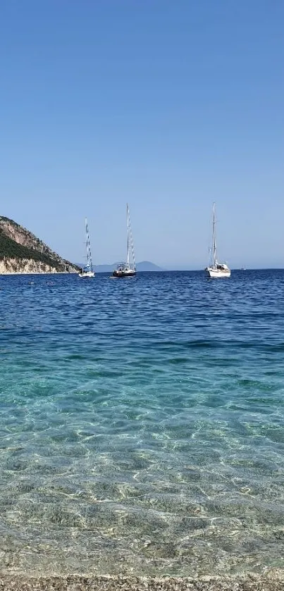 Peaceful beach with sailboats and clear blue ocean