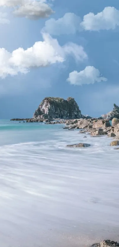 Tranquil beach with rocks under a cloudy sky at the ocean's edge.