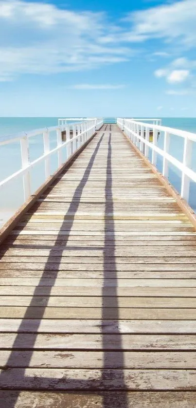 A tranquil pier stretches into the ocean under a bright blue sky, perfect as a wallpaper.