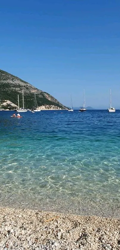 Mobile wallpaper of a serene beach with blue seas and sailboats.