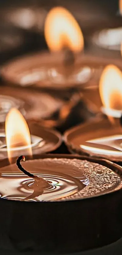 Close-up of glowing candle flames in a serene setting.