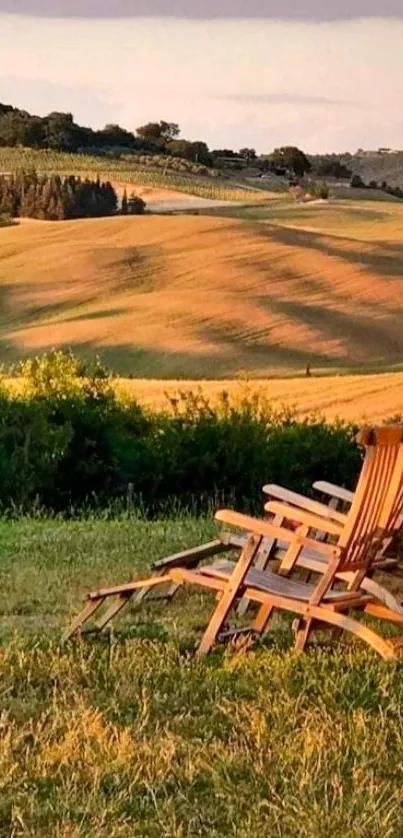 Countryside sunset with wooden chairs and rolling hills.