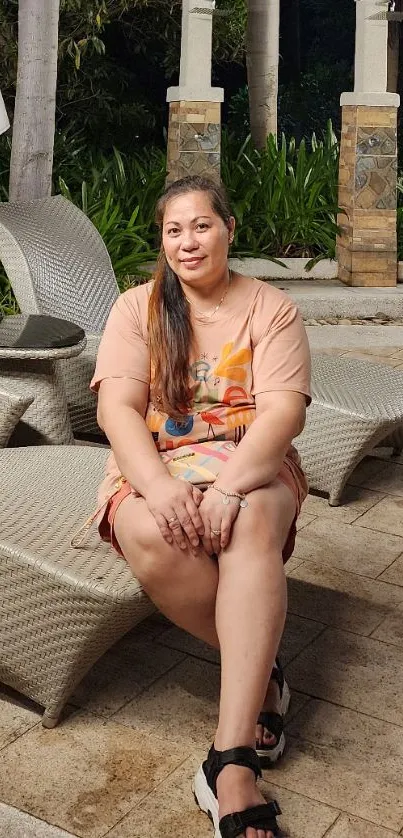 Woman relaxing on patio chair amidst lush greenery at night.