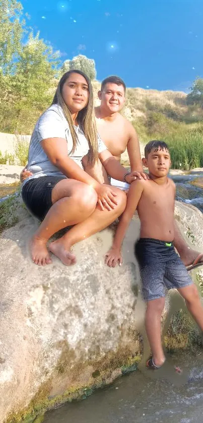 Family enjoying a serene day by the river with a clear blue sky.