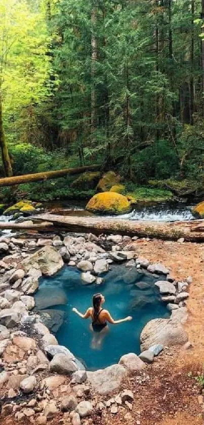 Person relaxing in a tranquil forest hot spring surrounded by lush greenery.