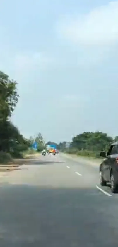 Serene highway surrounded by greenery and clear sky.