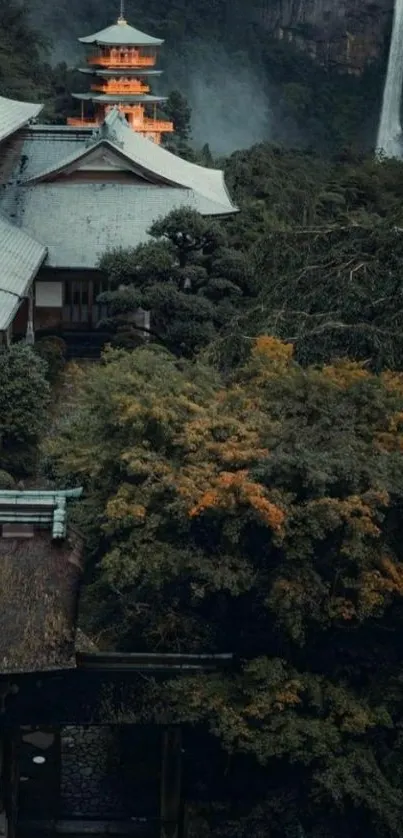 Japanese temple with forest and waterfall backdrop.