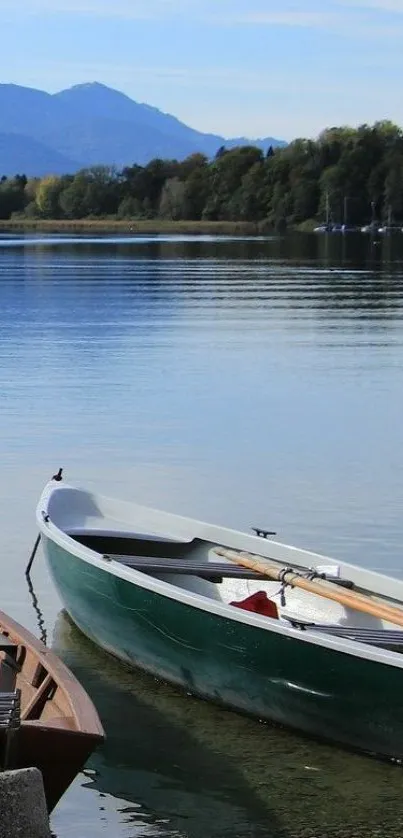 A serene lake with a wooden boat and distant mountains under a clear sky.